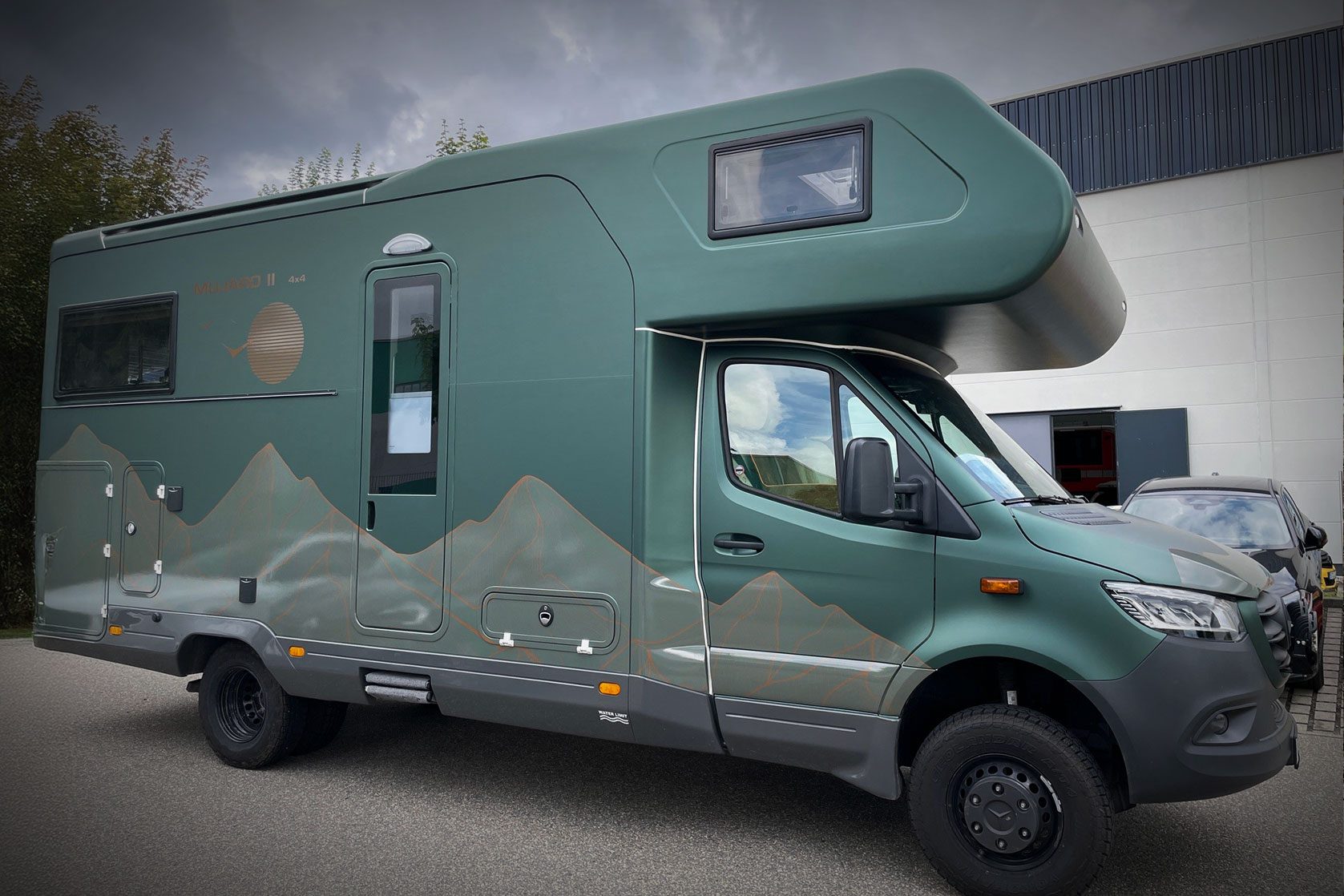 Wohnmobil mit matter Folierung in Grün und dezentem Bergmotiv