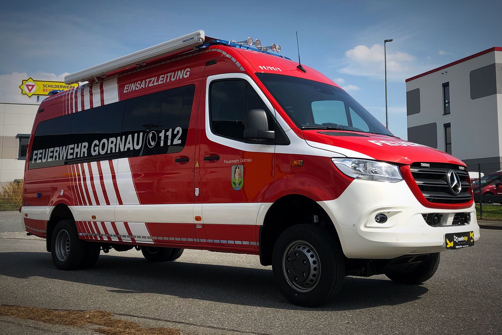 Einsatzleitfahrzeug der Feuerwehr Gornau mit roter Folierung, weißen Streifen und 112-Markierung.
