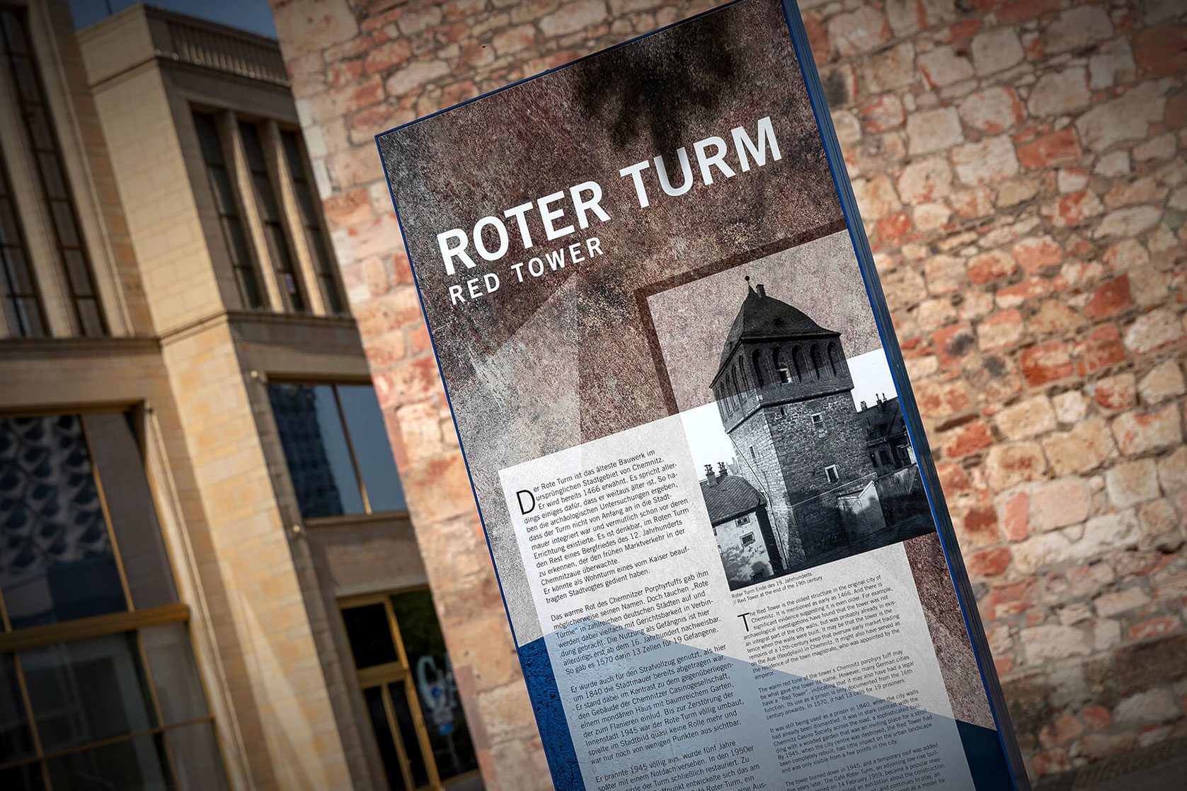 Infostele zum Roten Turm vor historischer Steinmauer in Chemnitz