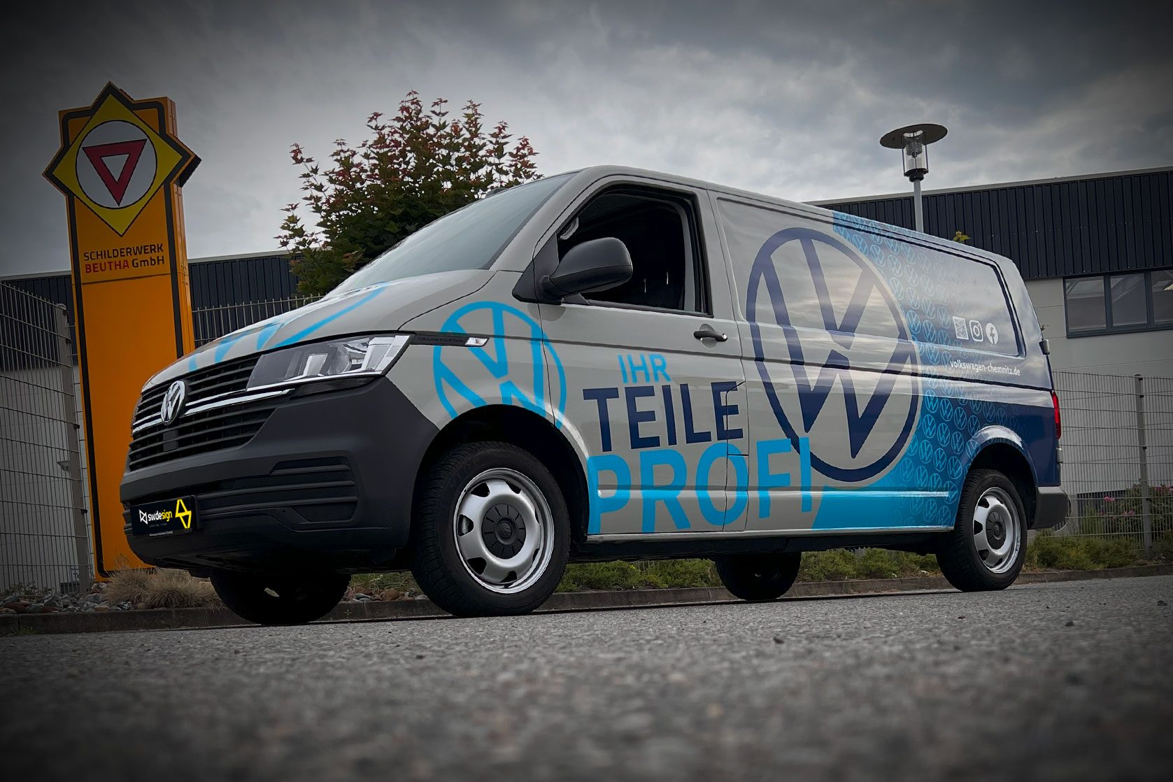 Volkswagen Transporter mit blauer Fahrzeugbeschriftung „Ihr Teileprofi“ und großem VW-Logo, umgesetzt von SW/DE/SIGN.
