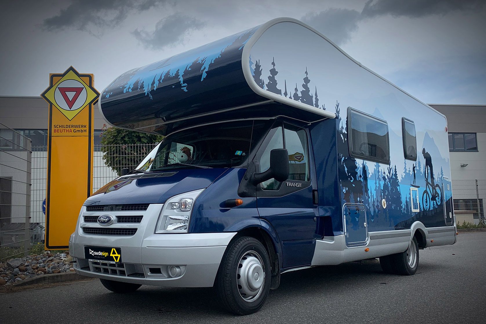 Wohnmobil mit individueller Folierung im Wald- und Bike-Motiv