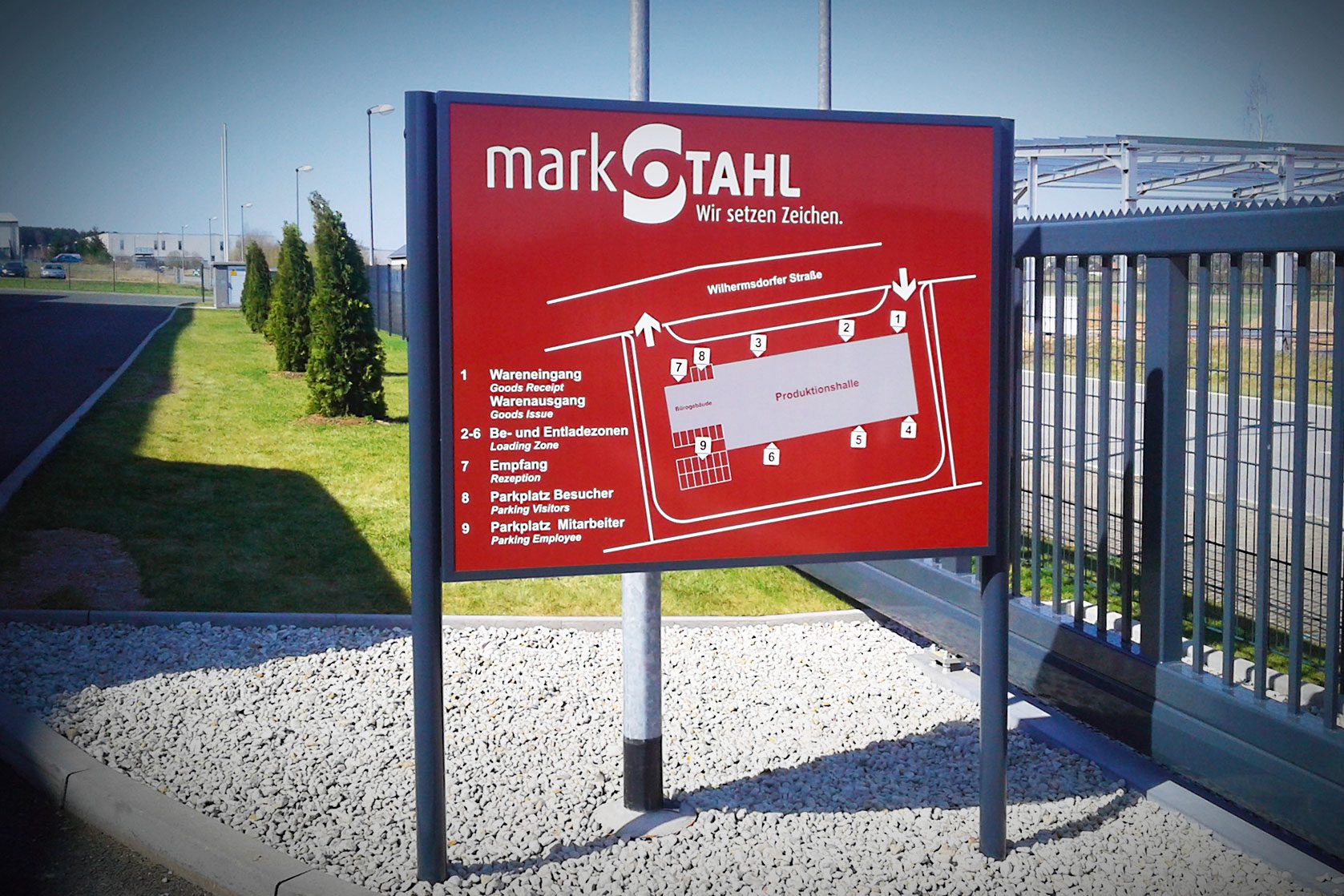 Rote Übersichtstafel mit Geländeplan vor Firmengelände von markSTAHL