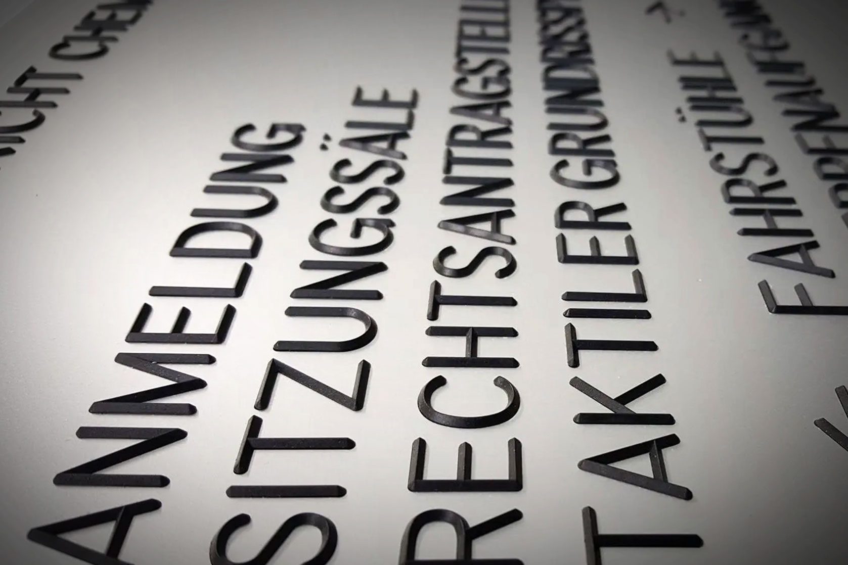 Taktile Buchstabenbeschriftung auf einer Wandtafel für Barrierefreiheit