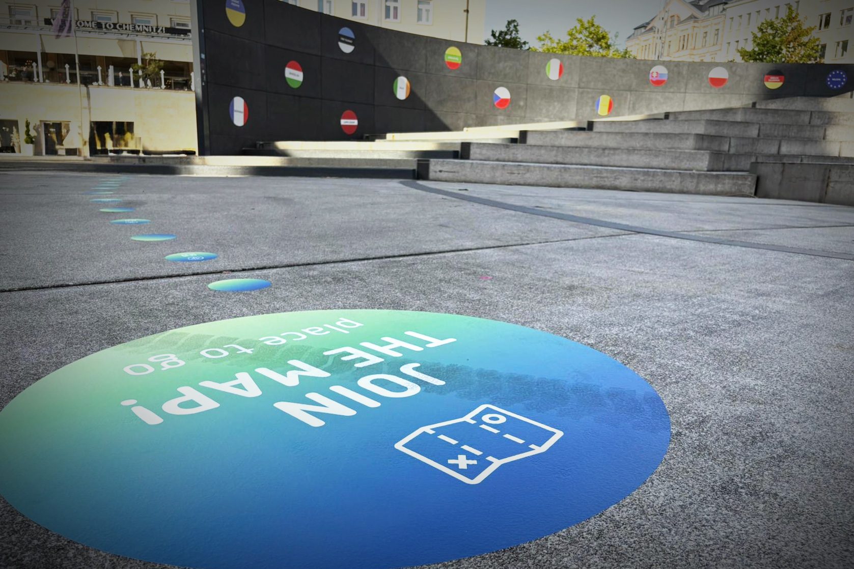 Farbiger Bodenaufkleber auf dem Markt Chemnitz mit Text „Join the Map! Place to go“