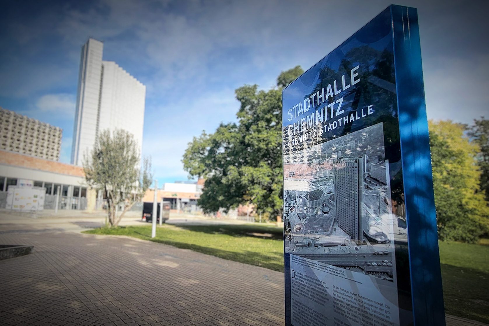 Blaue Informationsstele vor der Stadthalle Chemnitz mit Architektur-Visualisierung