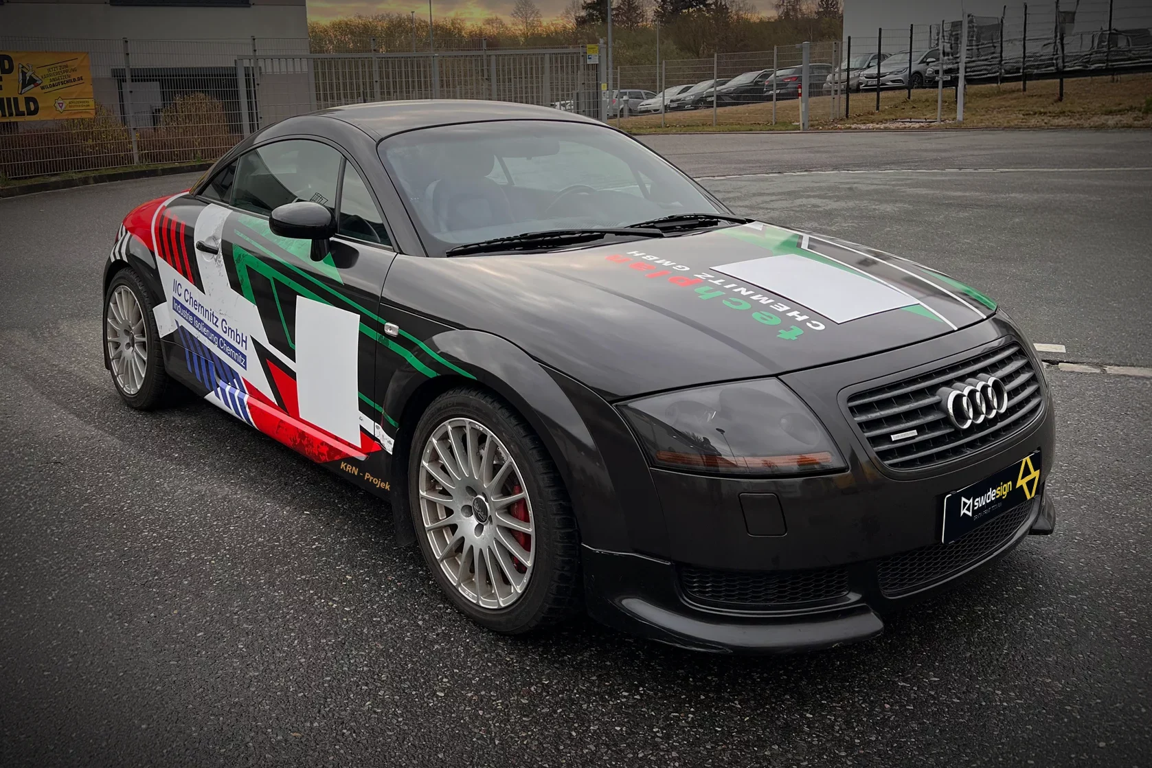 Schwarzer Audi TT mit individueller Teilfolierung und Werbegrafik, umgesetzt als PKW-Beklebung in Chemnitz.